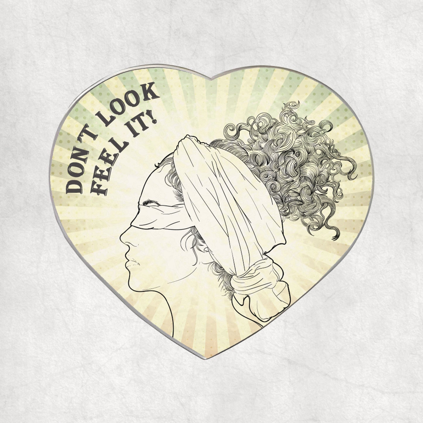 Heart-shaped metal magnet with a profile of a blindfolded woman and text 'DON'T LOOK FEEL IT!' text on a light vintage background.