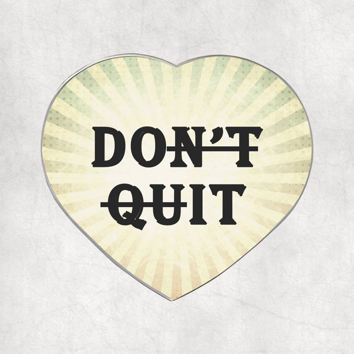 Heart-shaped metal magnet with 'DON'T QUIT' text on a light vintage background.