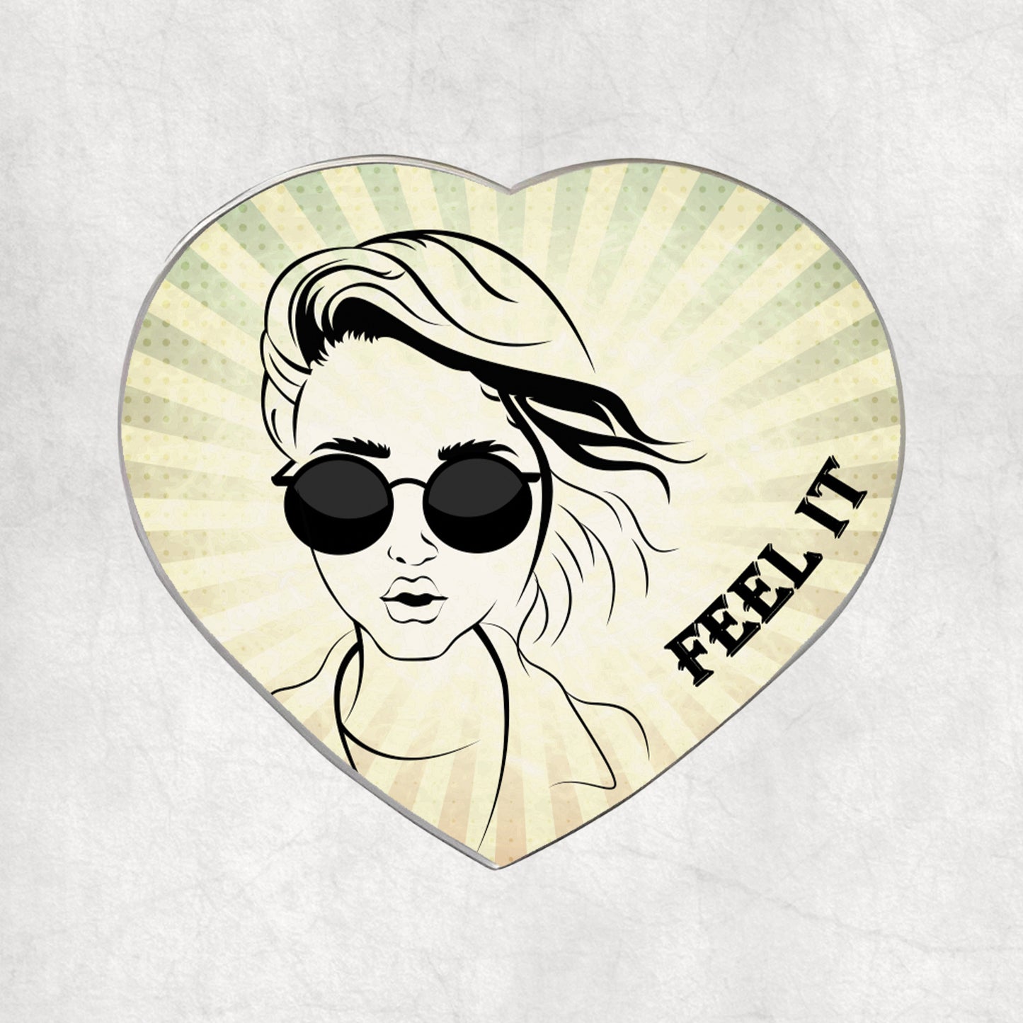 Heart-shaped metal magnet with a stylised face wearing sunglasses and 'FEEL IT' text on a light vintage background.