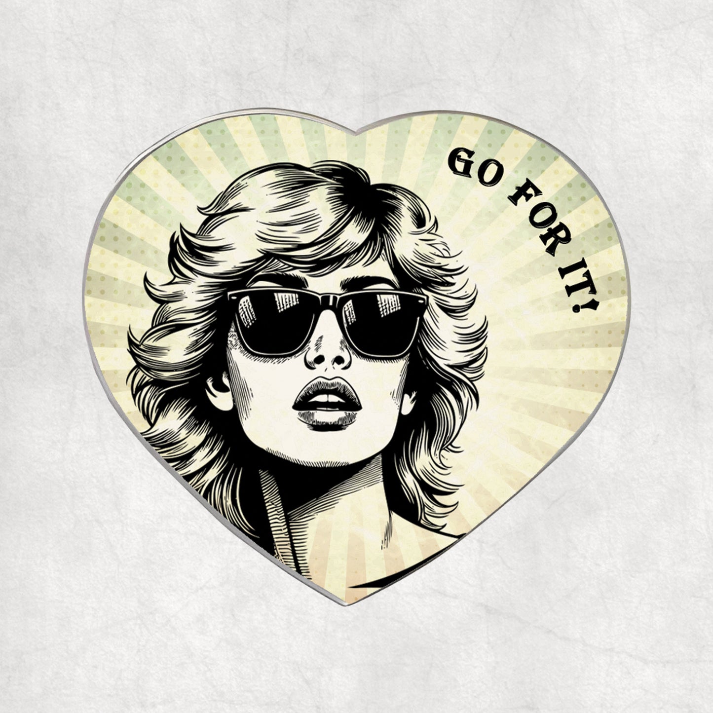 Heart-shaped metal magnet with a stylised portrait of a woman wearing sunglasses and 'GO FOR IT!' text on a light vintage background.