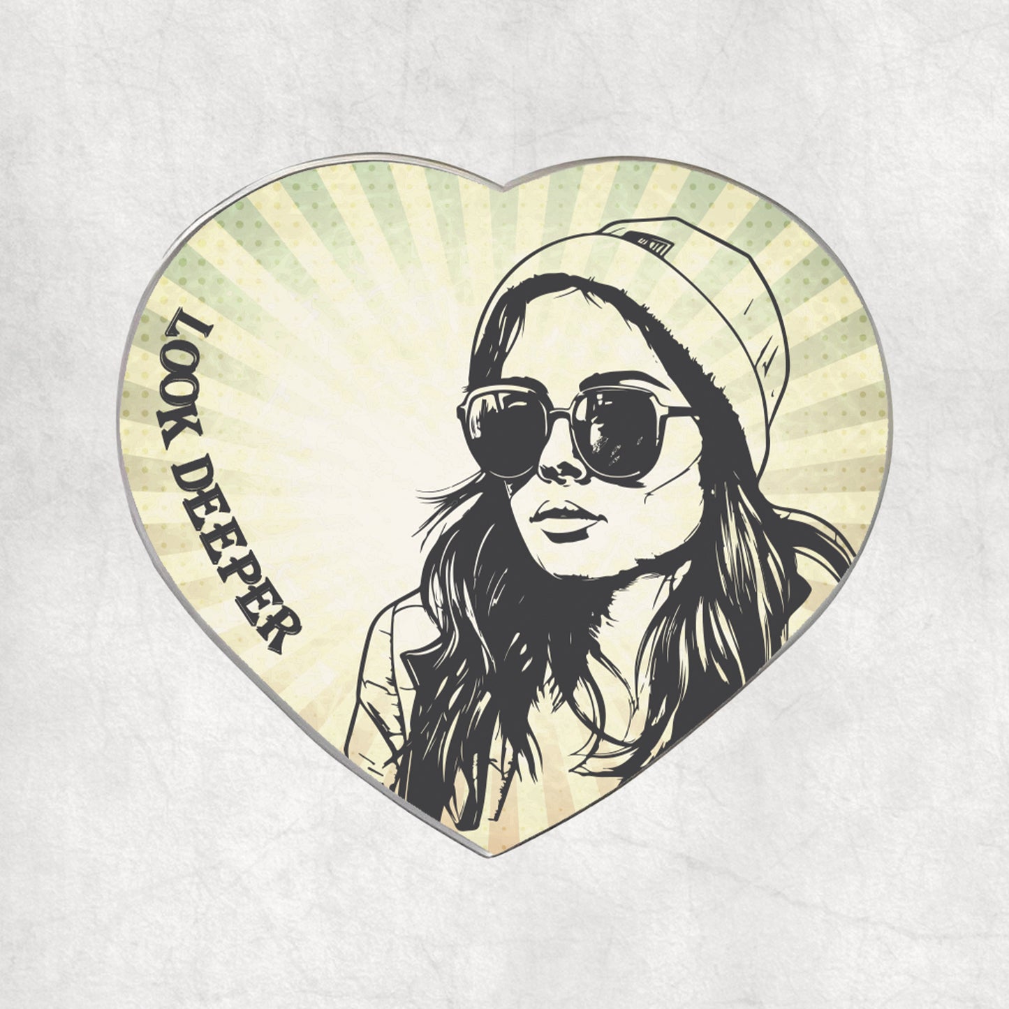 Heart-shaped metal magnet with a stylized portrait of a woman wearing sunglasses and a beanie, with 'Look Deeper' text on the light vintage background.