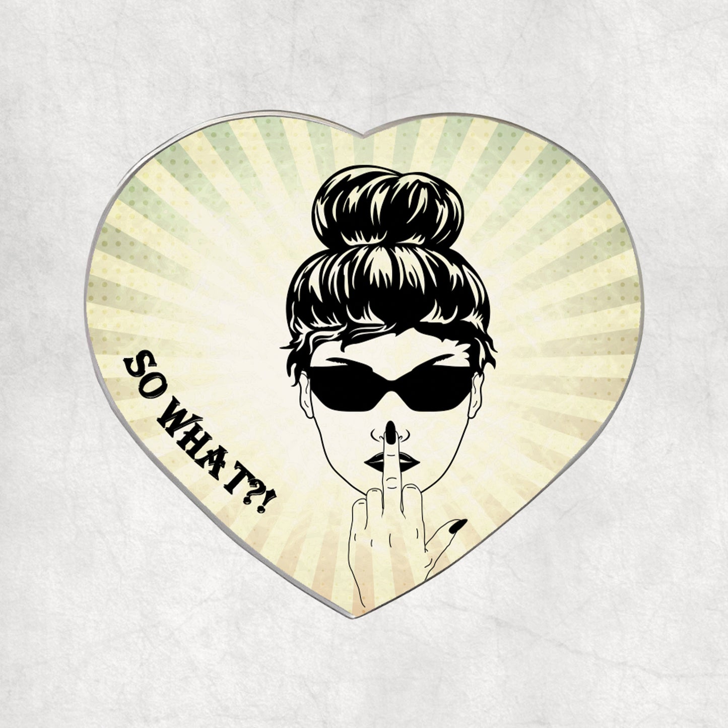 Heart-shaped metal magnet with a stylised face, sunglasses, and 'So What?!' text on a light vintage background.