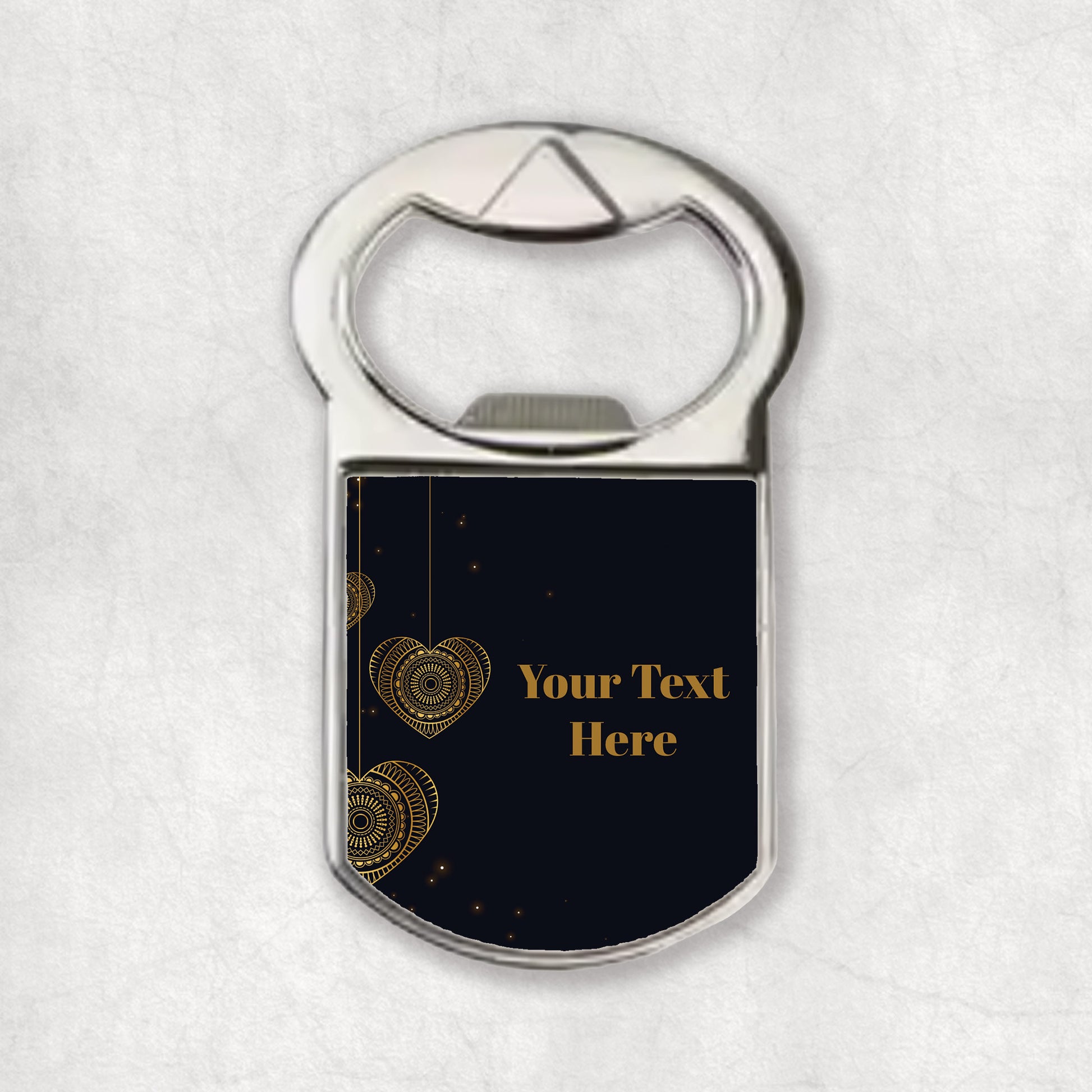 A bottle opener magnet with a dark background and gold hearts, with a text placeholder text saying 'Your Text Here'.