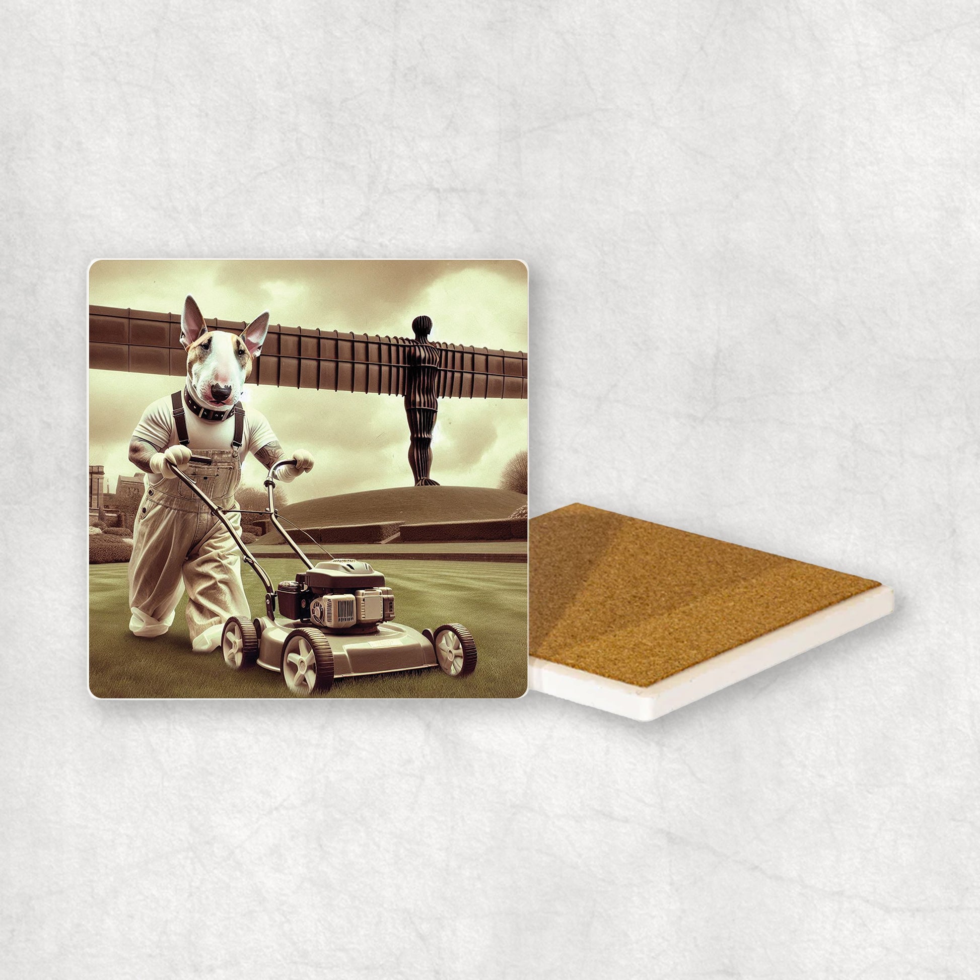 Ceramic coaster gift with a Bull Terrier dog design, dressed as a gardener, mowing the grass with a lawnmower, with the Angel of the North in the background.