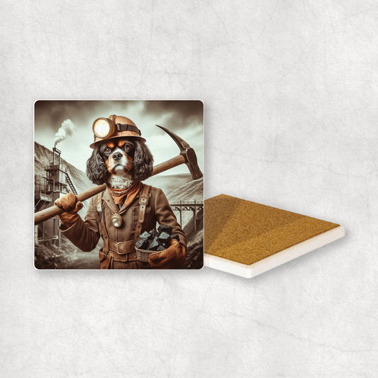 Ceramic Coaster gift with a Cavalier dog design, dressed like a miner with a pickaxe and coal in its paws, with a mine in the background.