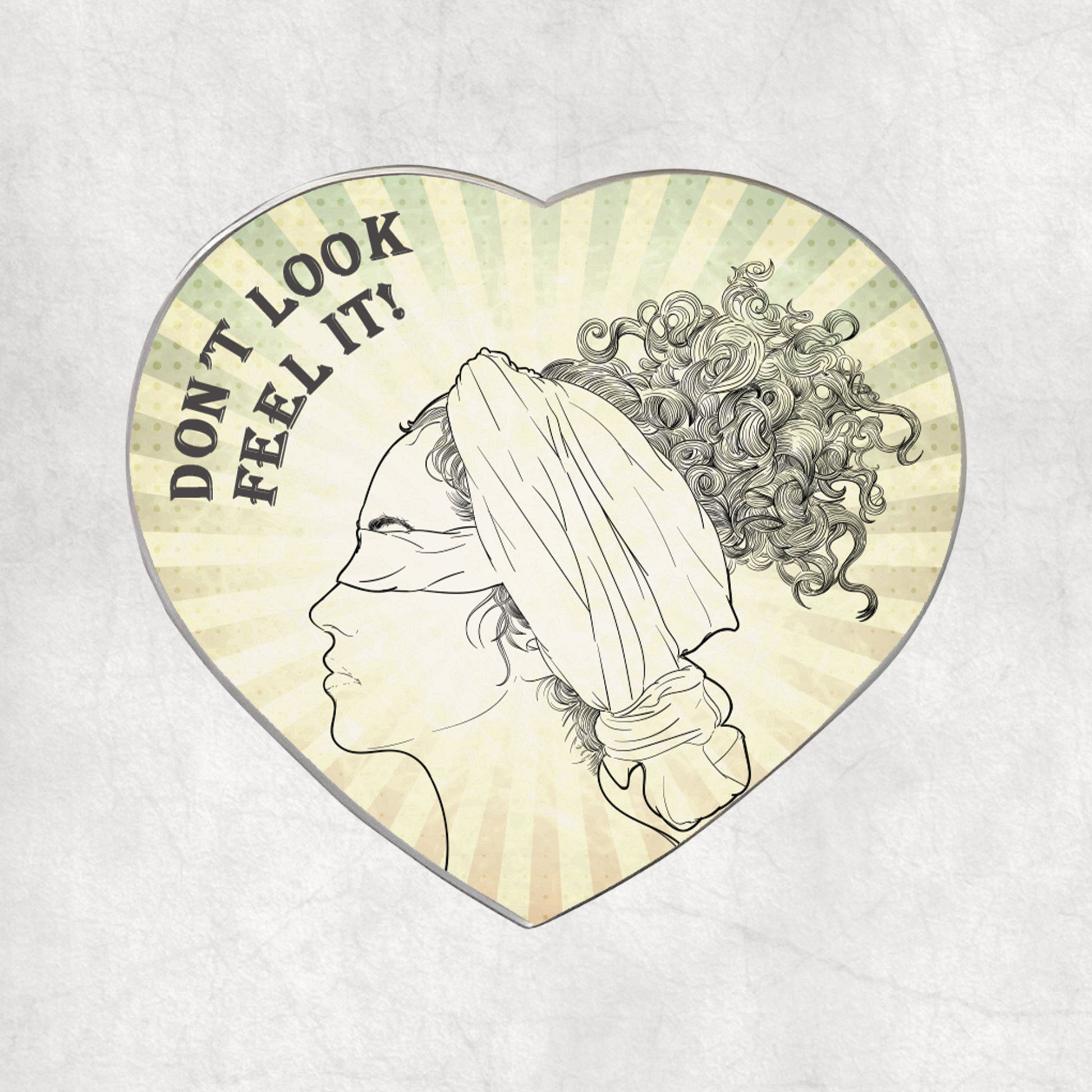 Heart-shaped metal magnet with a profile of a blindfolded woman and text 'DON'T LOOK FEEL IT!' text on a light vintage background.