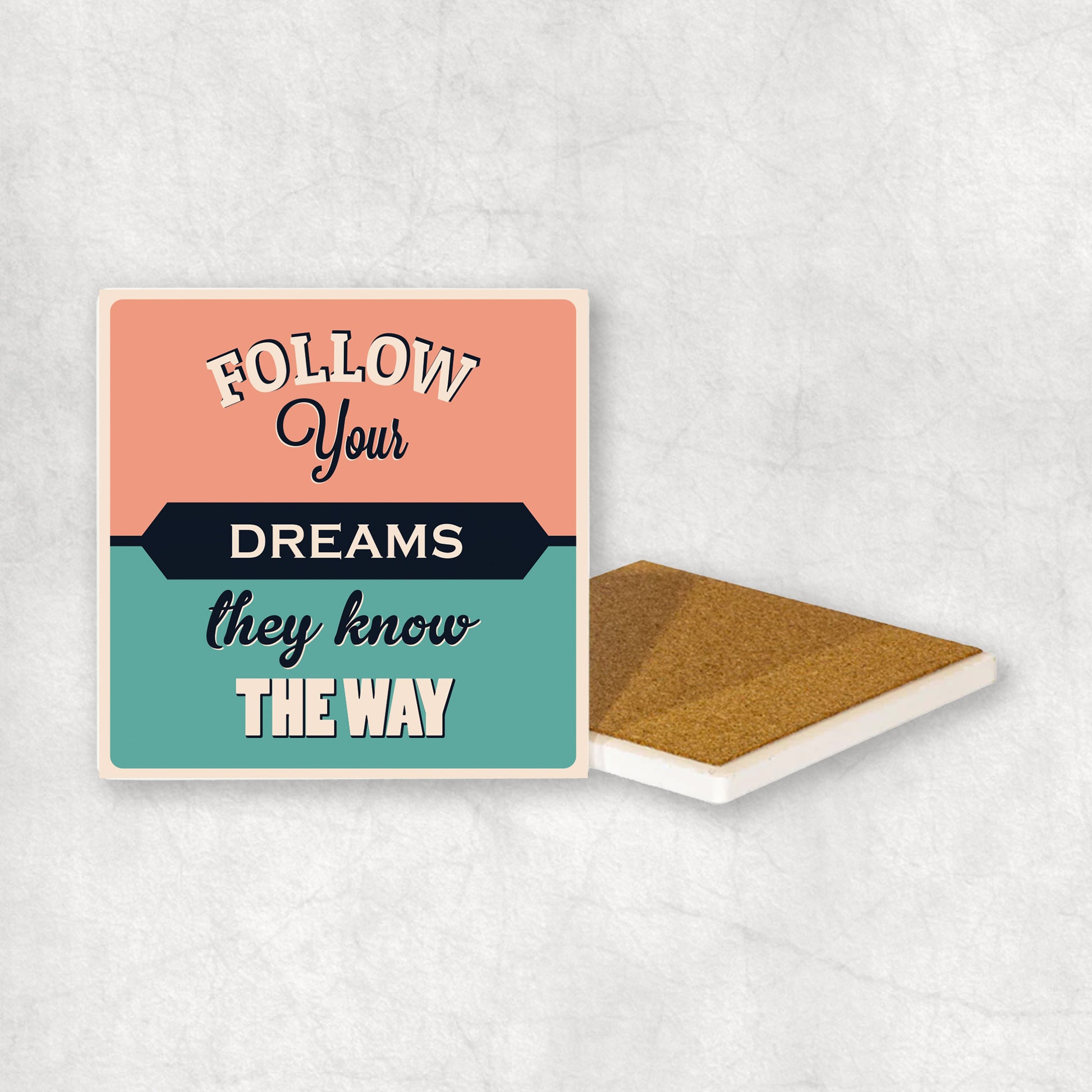 Inspiring ceramic coaster with 'Follow your dreams they know the way' text, perfect gift for any occasion.