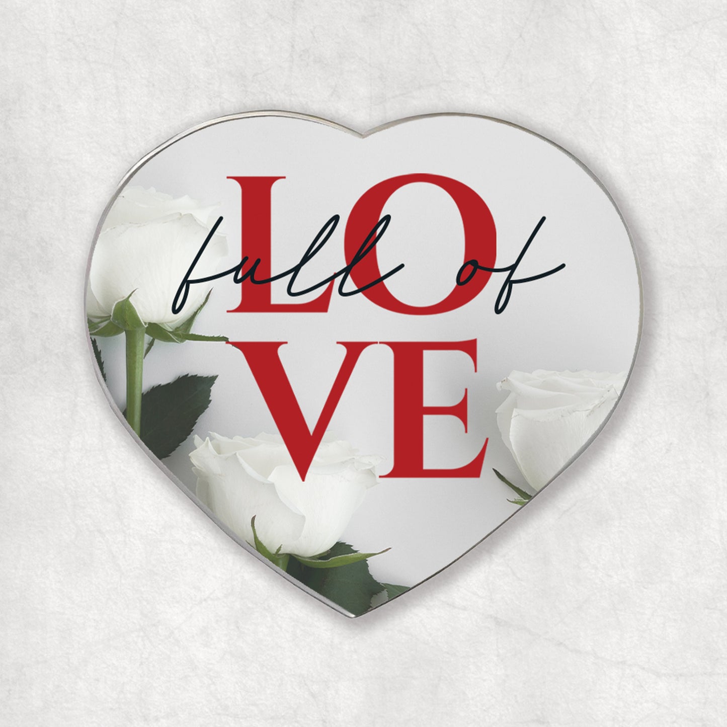 A heart-shaped magnet with the 'Full of LOVE' red phrase, on a light background with white roses at the bottom.