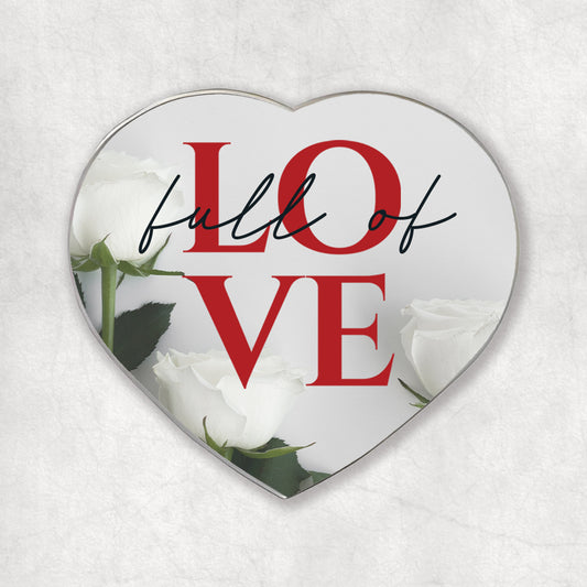 A heart-shaped magnet with the 'Full of LOVE' red phrase, on a light background with white roses at the bottom.