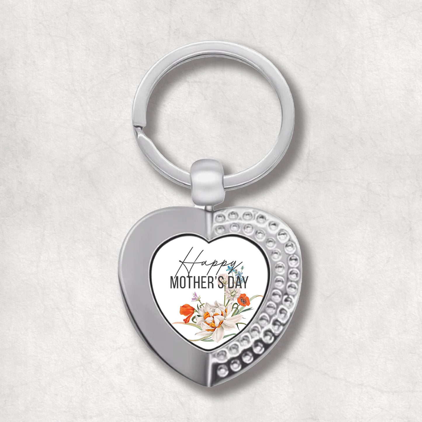 An elegant heart-shaped keyring with a printed message 'Happy Mother's Day' surrounded by poppy flowers.