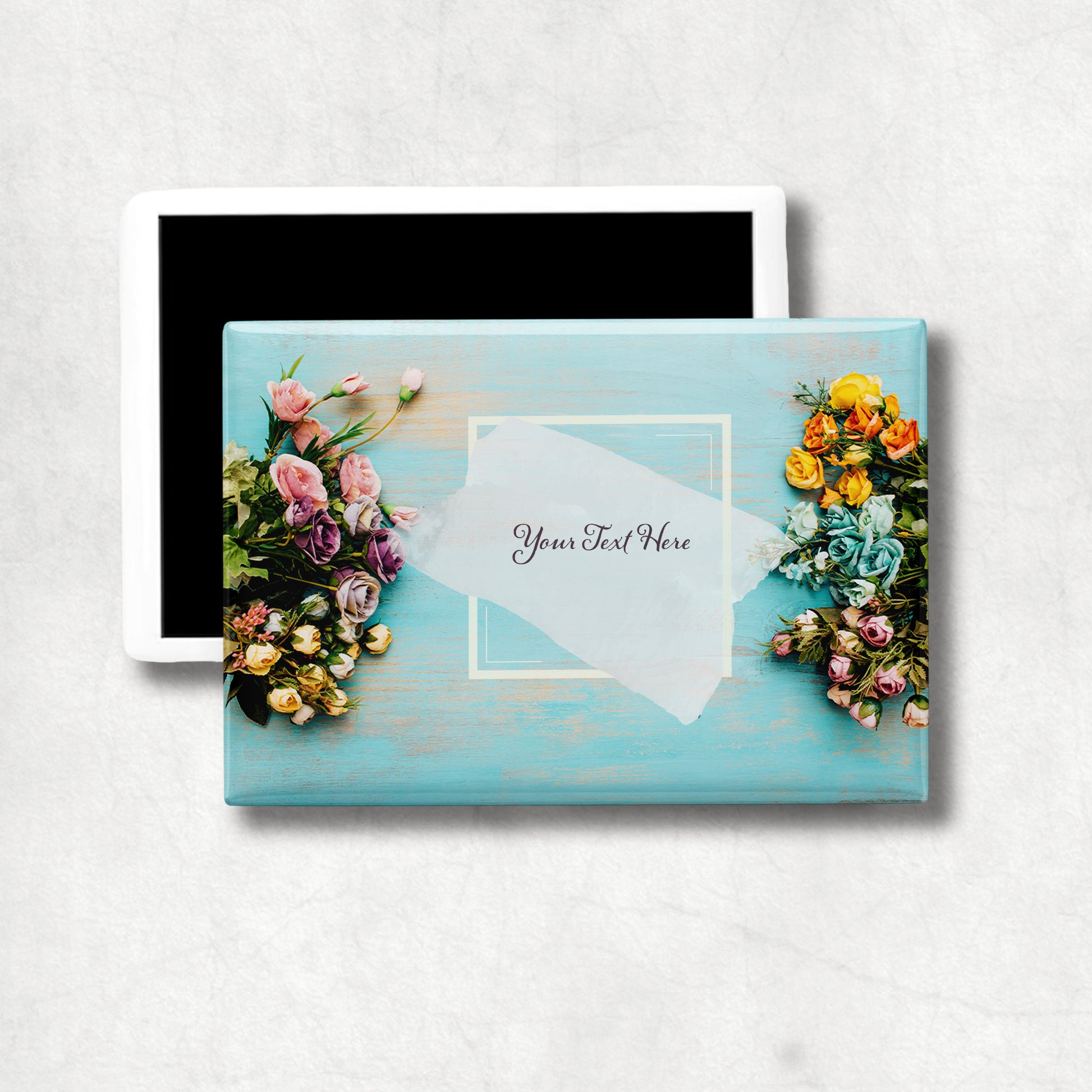 Horizontal ceramic magnet with floral design and customizable text area on a light blue background.