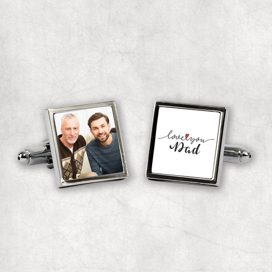 A pair of silver personalised cufflinks with one featuring a photo 
 and the other with the 'Love you Dad' text on a white background.