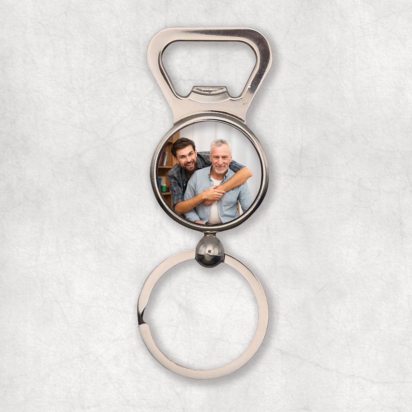 A silver bottle opener keyring with a circular photo print in the center. 