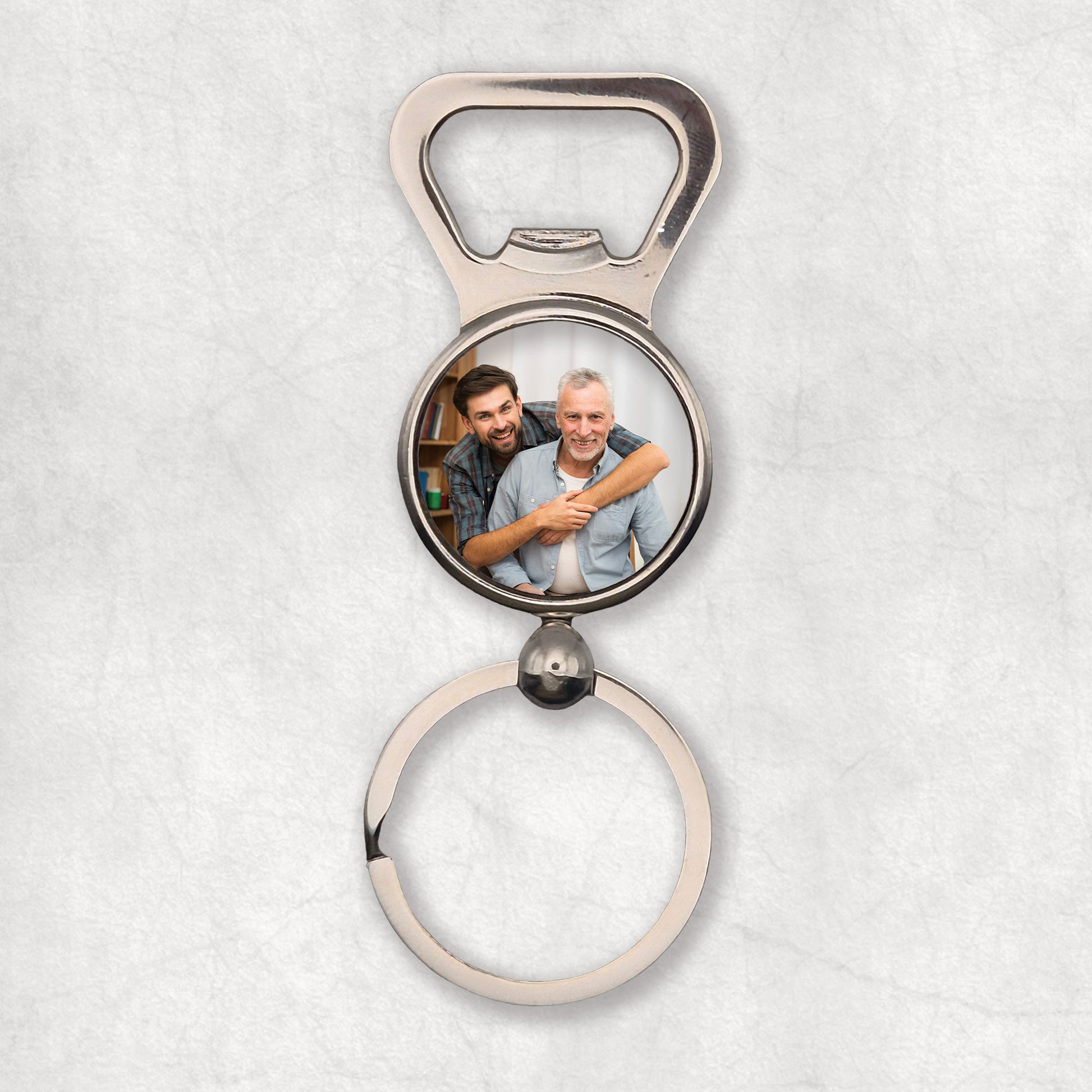 A silver bottle opener keyring with a circular photo print in the center. 