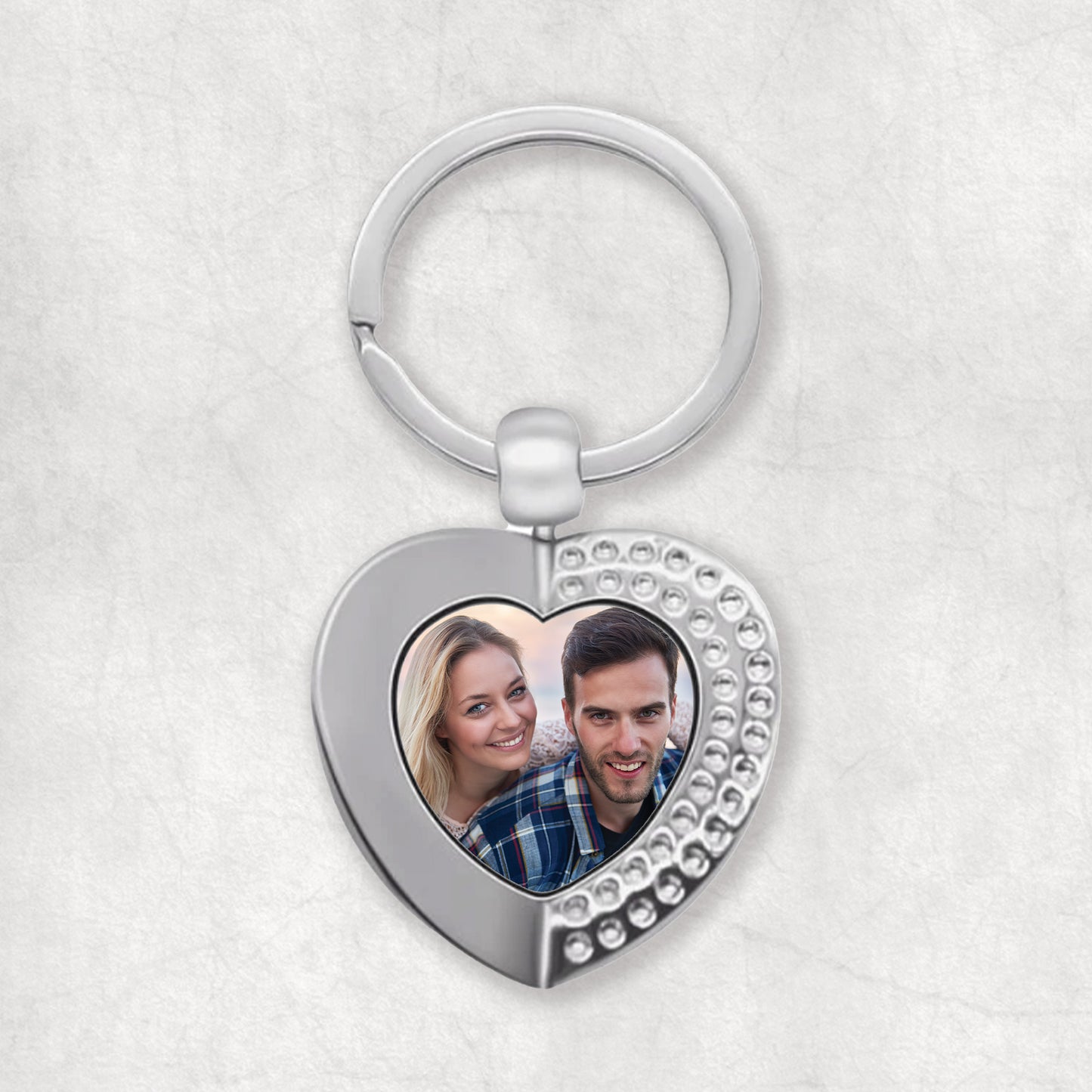 A heart-shaped keyring with a personalised photo printed on the front, attached to a keychain.
