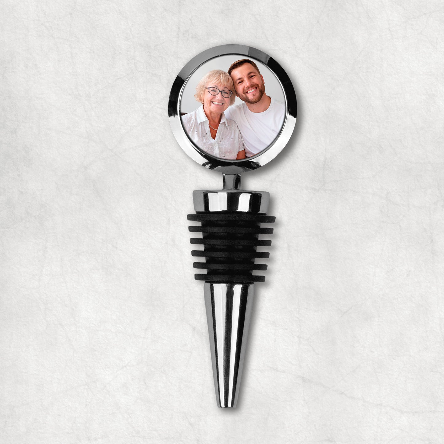 A personalised photo wine bottle stopper, made of metal and black rubber, the perfect gift for Mother's Day.