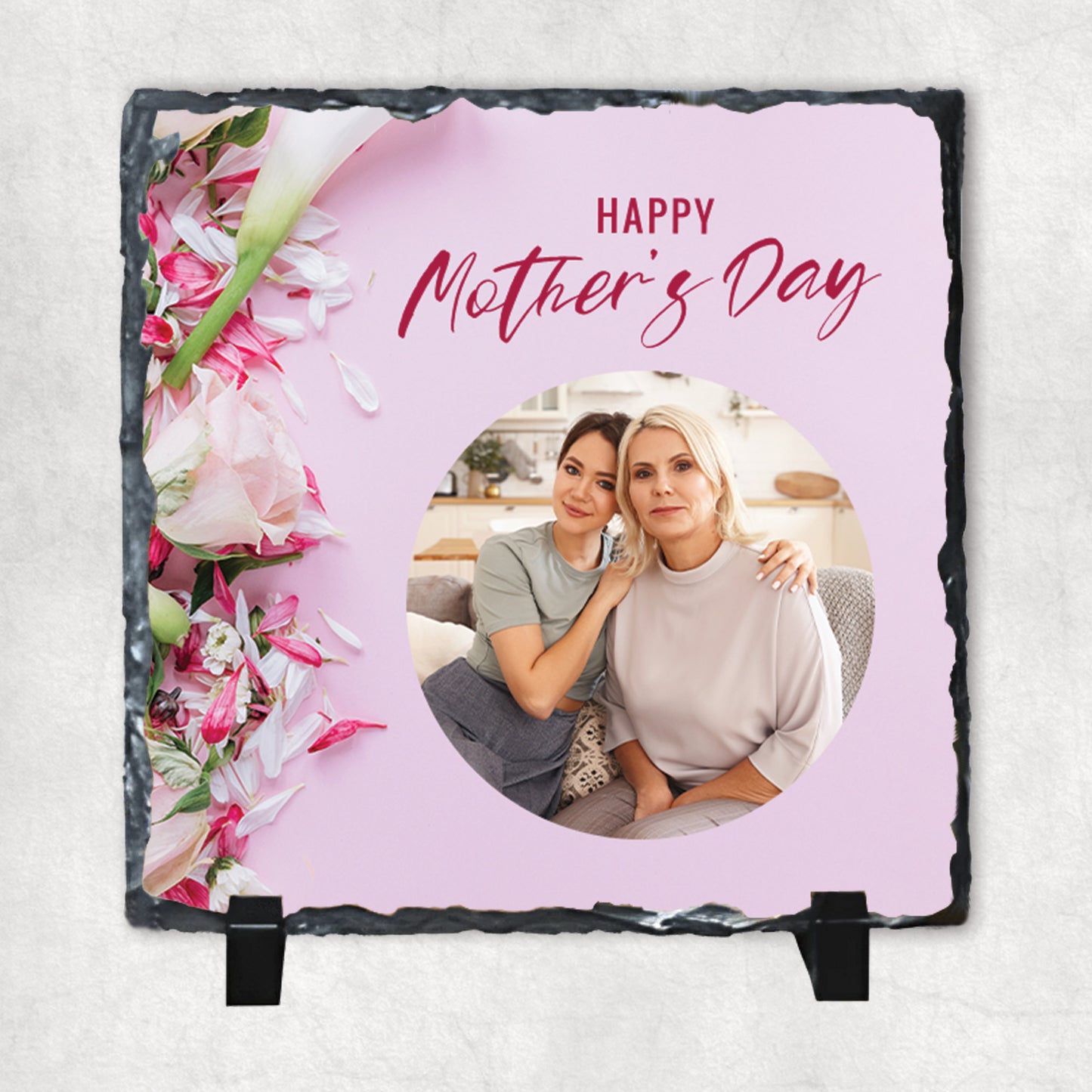 A personalised photo print on a rock slate with pink text saying 'Happy Mother's Day'.