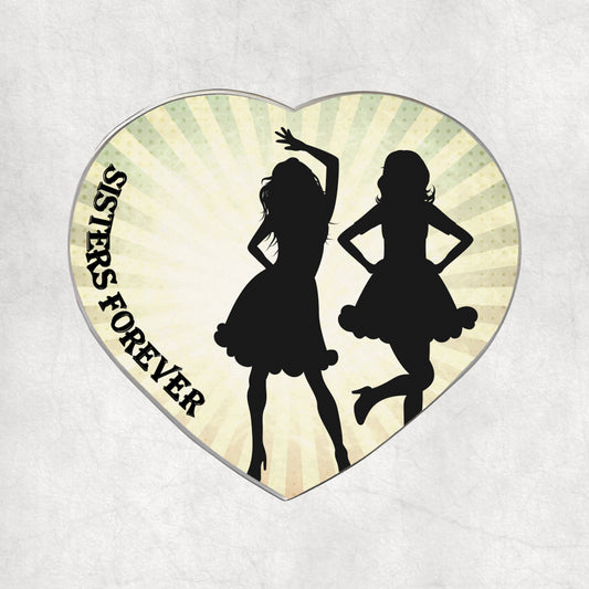 Heart-shaped metal magnet with silhouettes of two girls dancing and 'SISTERS FOREVER' text on a light vintage background.