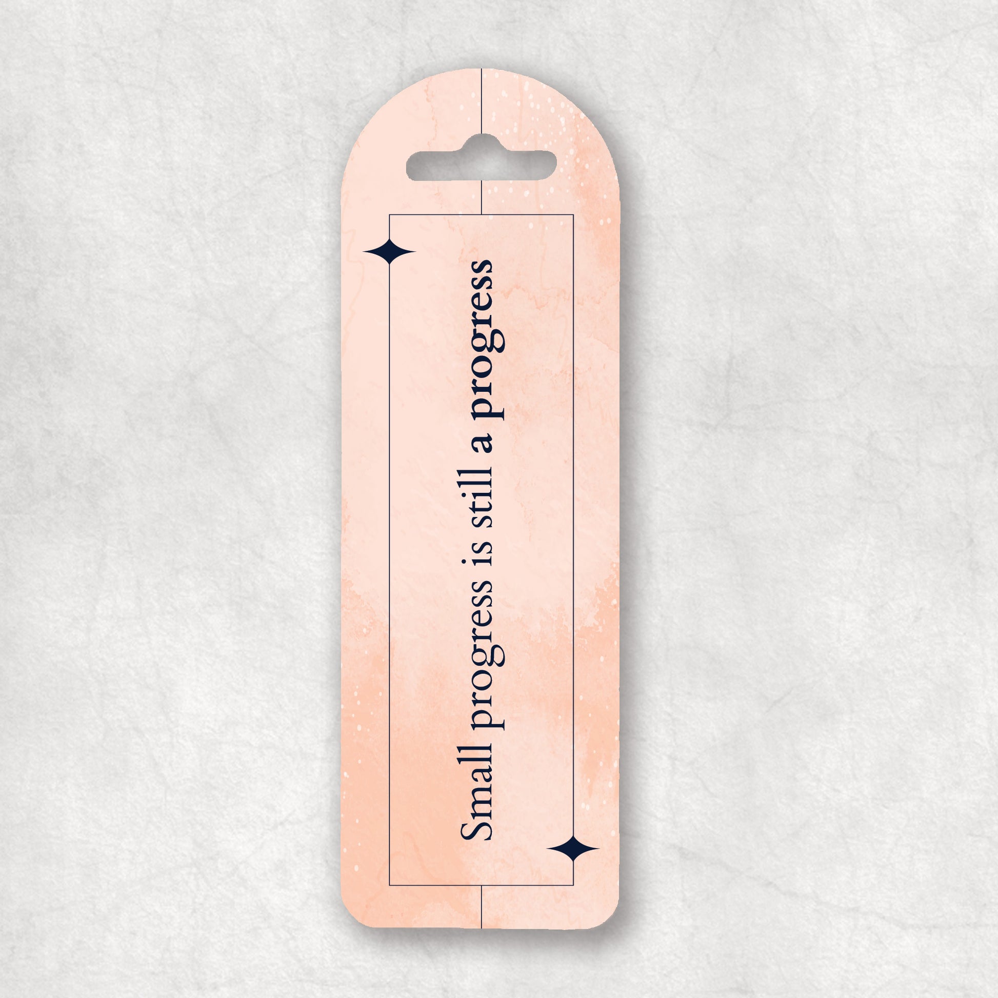 Inspiring bookmark with 'Small progress is still a progress' text on a light pink background, the perfect gift for any occasion. 
