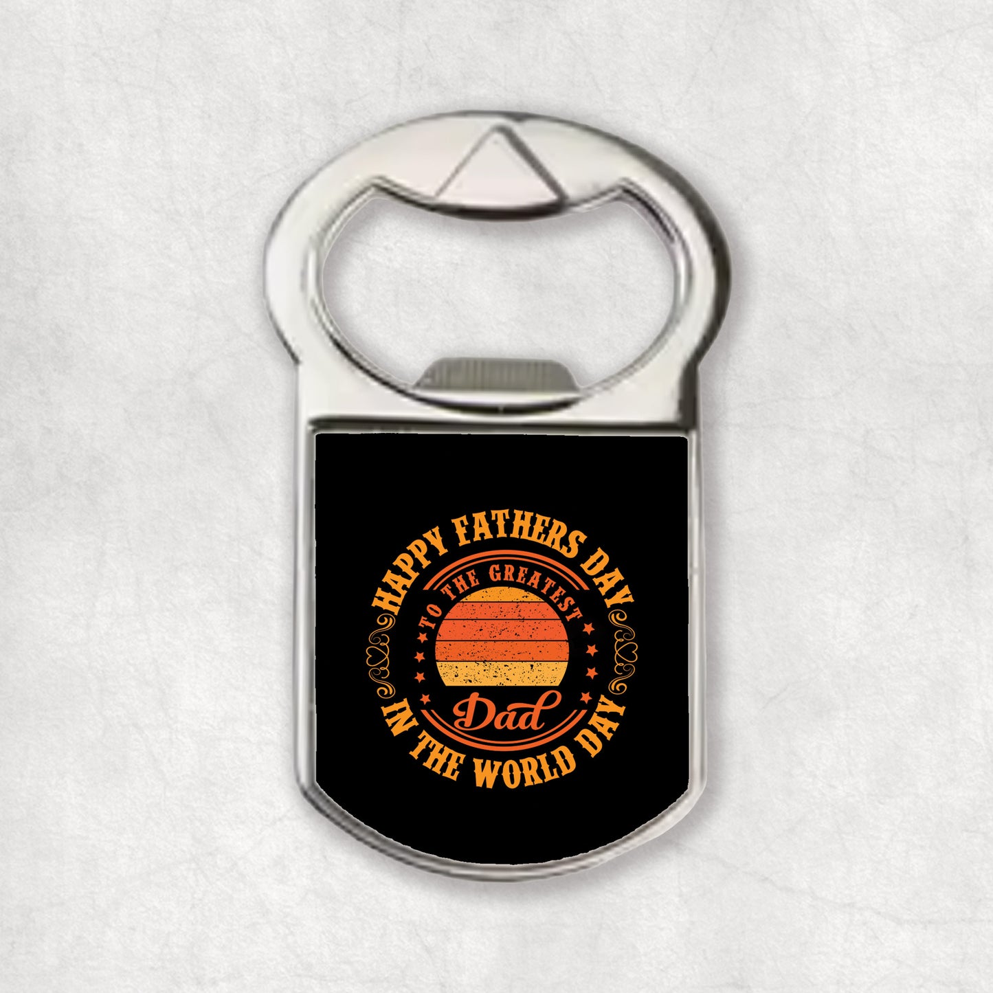 A bottle opener magnet with text and a circular graphic that reads 'Happy Father's Day to the Greatest Dad In The World'.