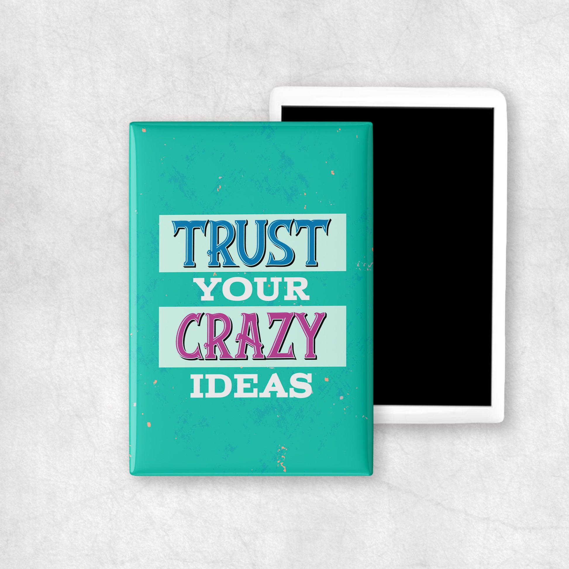 A vertical ceramic magnet with a 'TRUST YOUR CRAZY IDEAS' text on turquoise background, a perfect gift for any occasion.