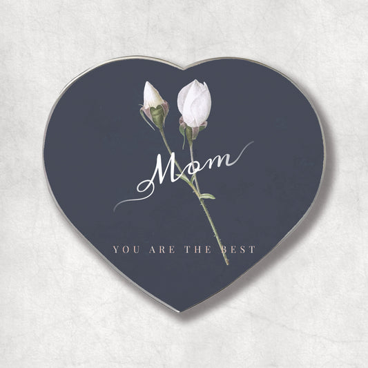 A heart-shaped metal magnet with the 'Mom YOU ARE THE BEST' text on a dark background, accompanied by an image of two white roses.
