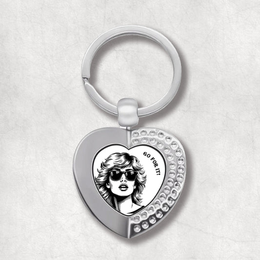 Metal heart-shaped keychain with a woman's portrait and 'go for it!' text written on a white background.